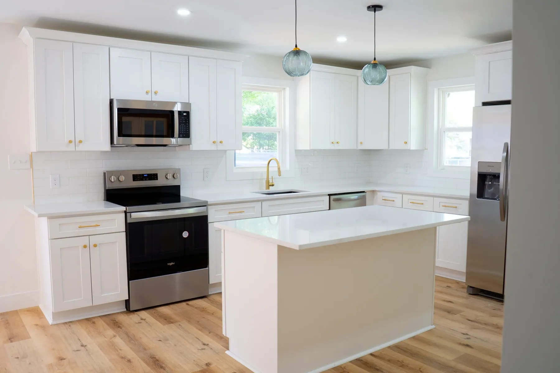 White shaker kitchen with island and glass pendant lights