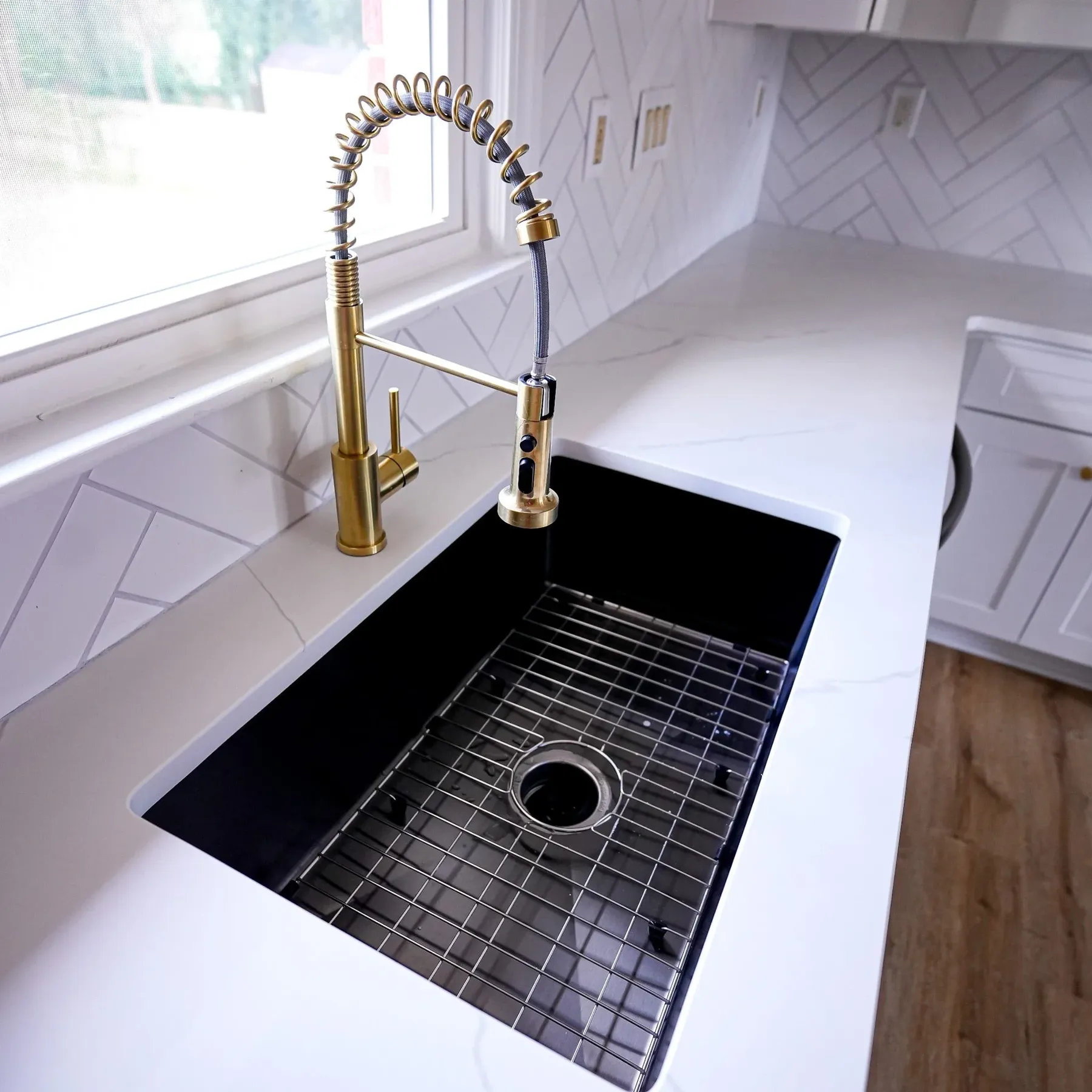 Black sink with brass pull-down faucet