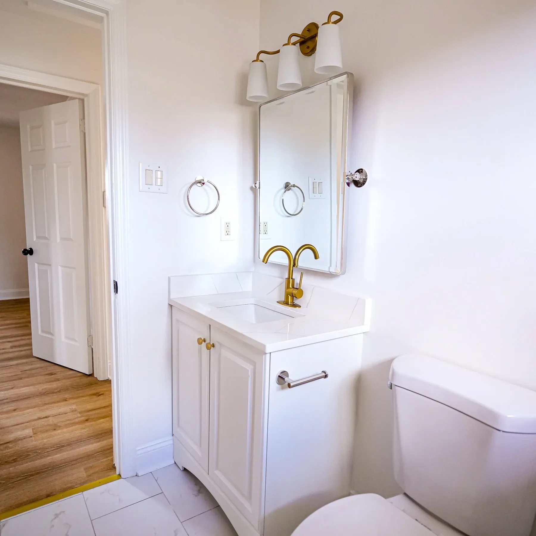 Vanity with brass faucet and sconce