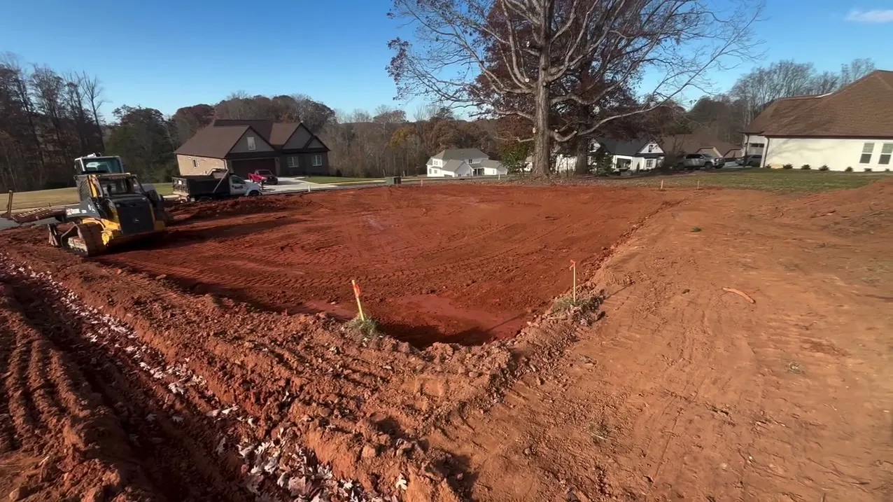 Red clay graded at the Holy Circle site with a skid steer