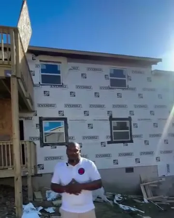 Kirk in front of a building in house wrap with new windows