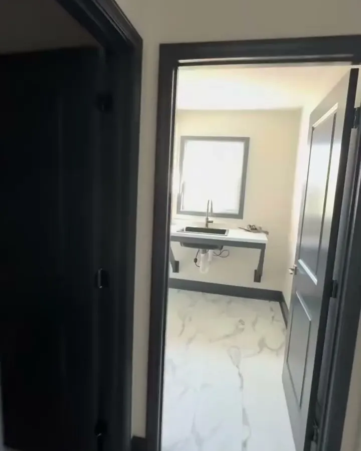 Finished hallway with black doors and marble-look floors